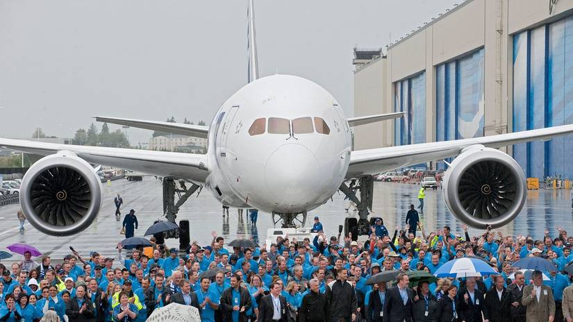 Employees walk alongside the first 787 Dreamliner delivered in 2011 to present it to launch customer ANA.