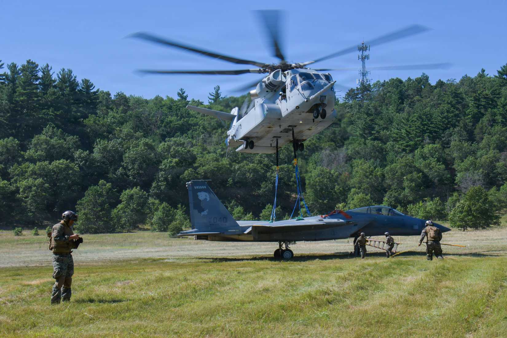 Marines assigned to Marine Operational Test & Evaluation Squadron 1 use a CH-53K King Stallion helicopter to transport a recovered F-15 Eagle aircraft