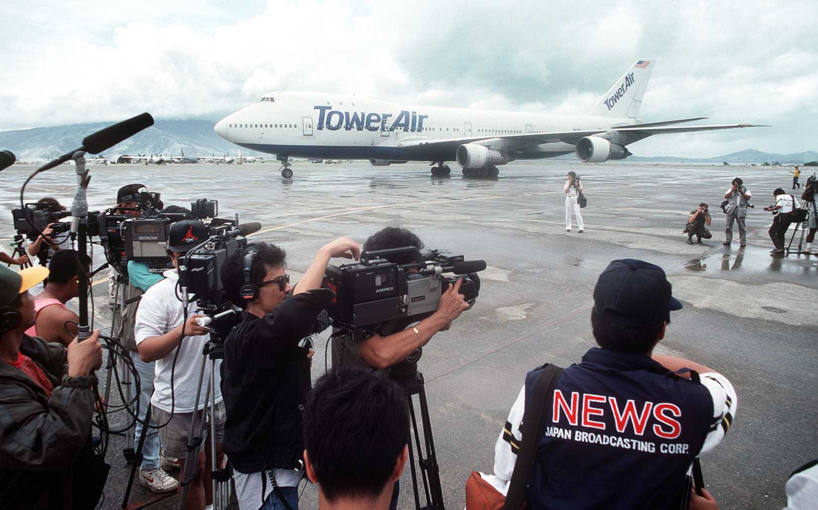 Members of the media film a Boeing 747 commercial aircraft after its arrival at the station.