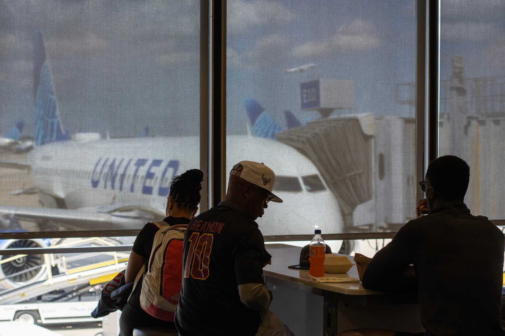 Passengers wait at the terminal lounge facing the airport tarmac in Chicago's O'Hare International Airport