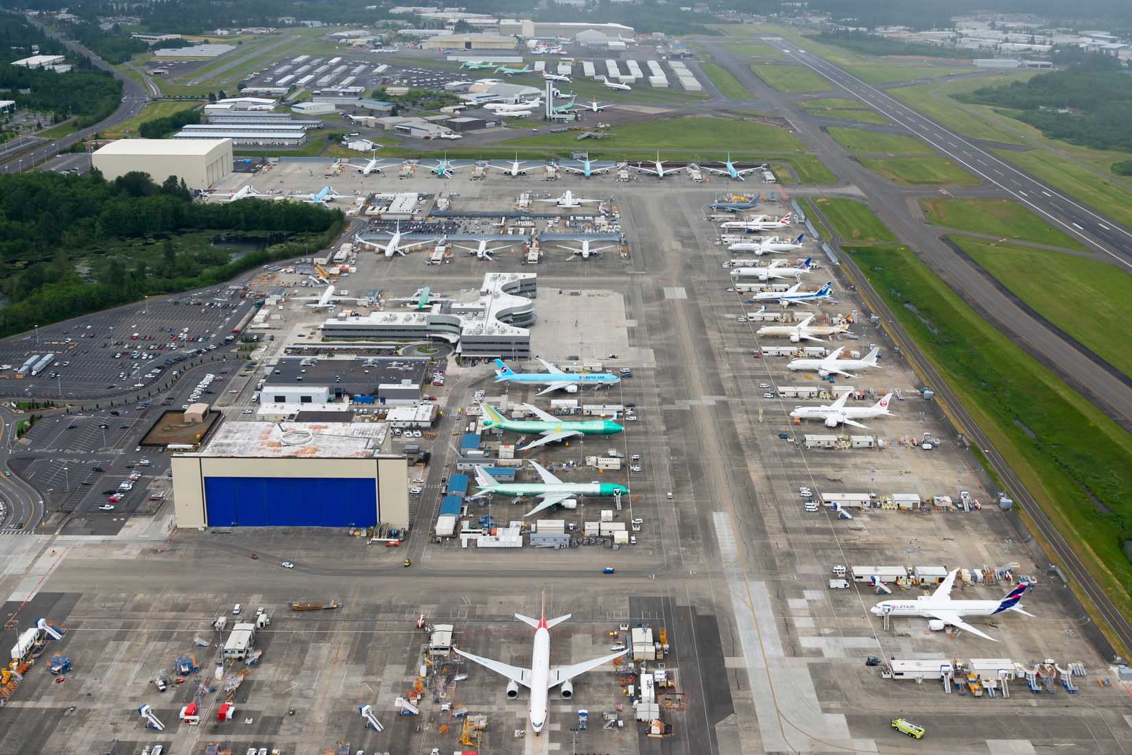 Everett, Washington / USA - May 22 2016: Aerial overview of Boeing factory, ramp, and hangars at Paine Field. Aircrafts waiting for test and delivery flights. Cargo and passenger airplanes.