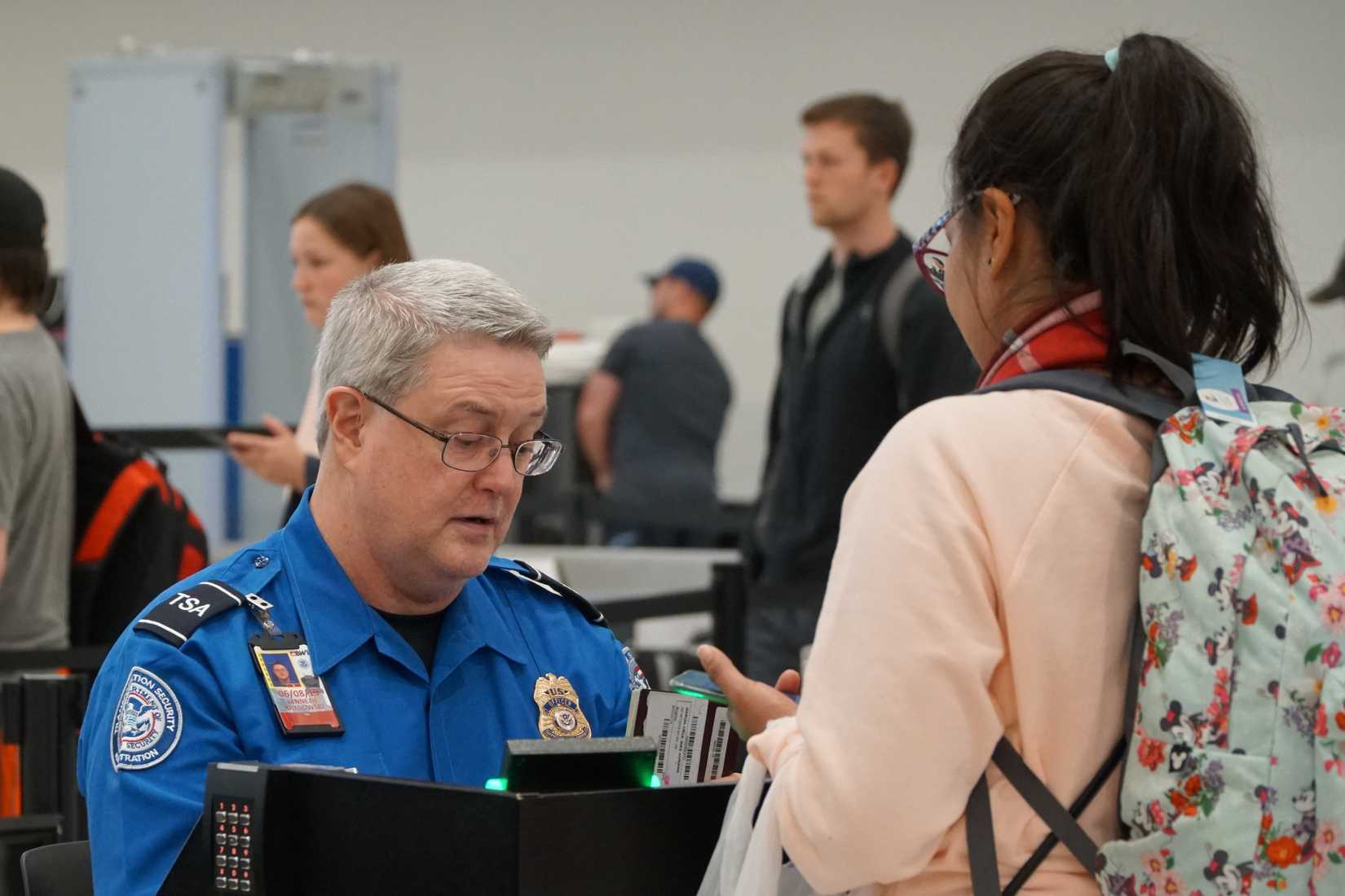 TSA worker checks out passport at BWI