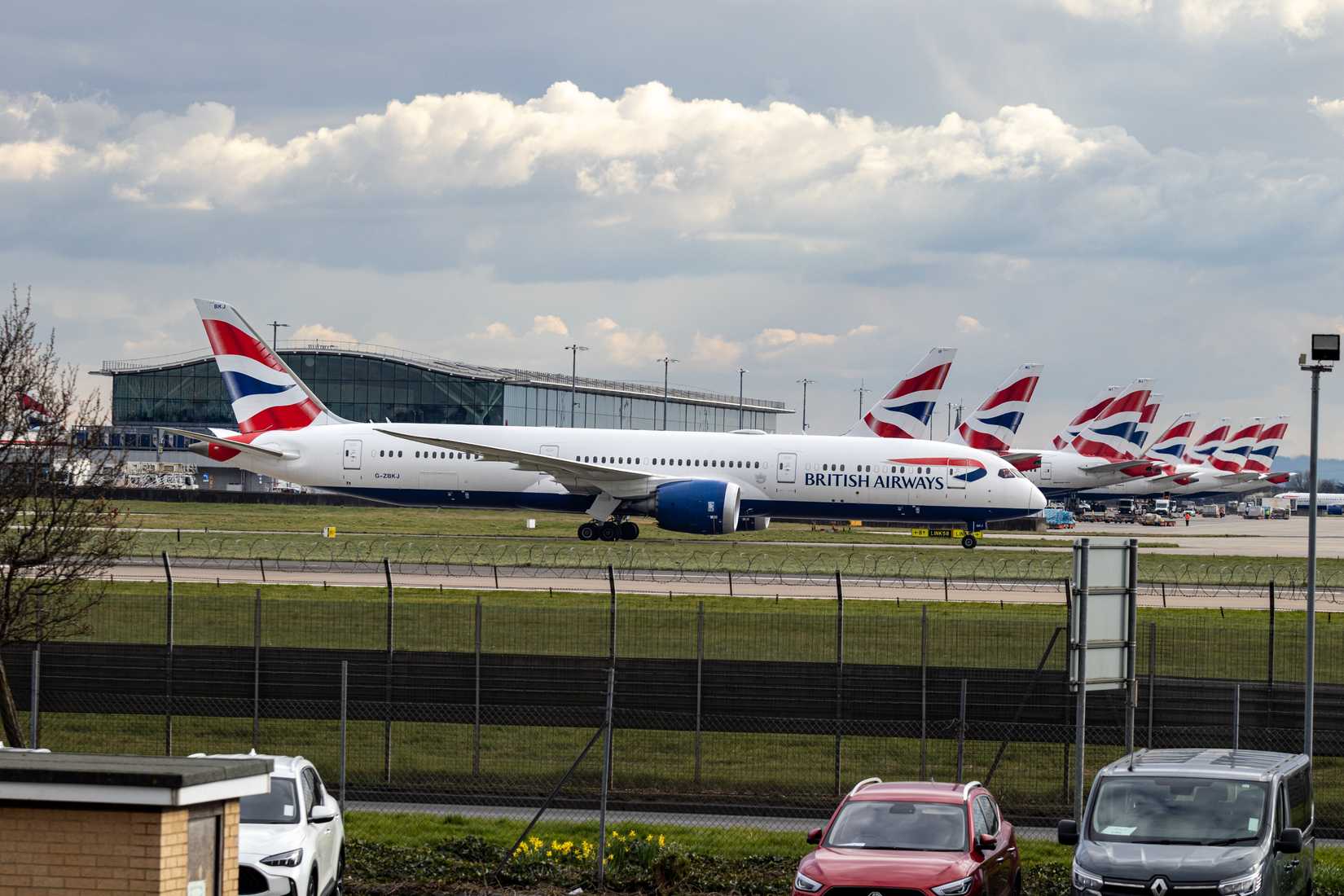 British Airways Boeing 787-9 Dreamliner taxiing with other BA aircraft parked in the background