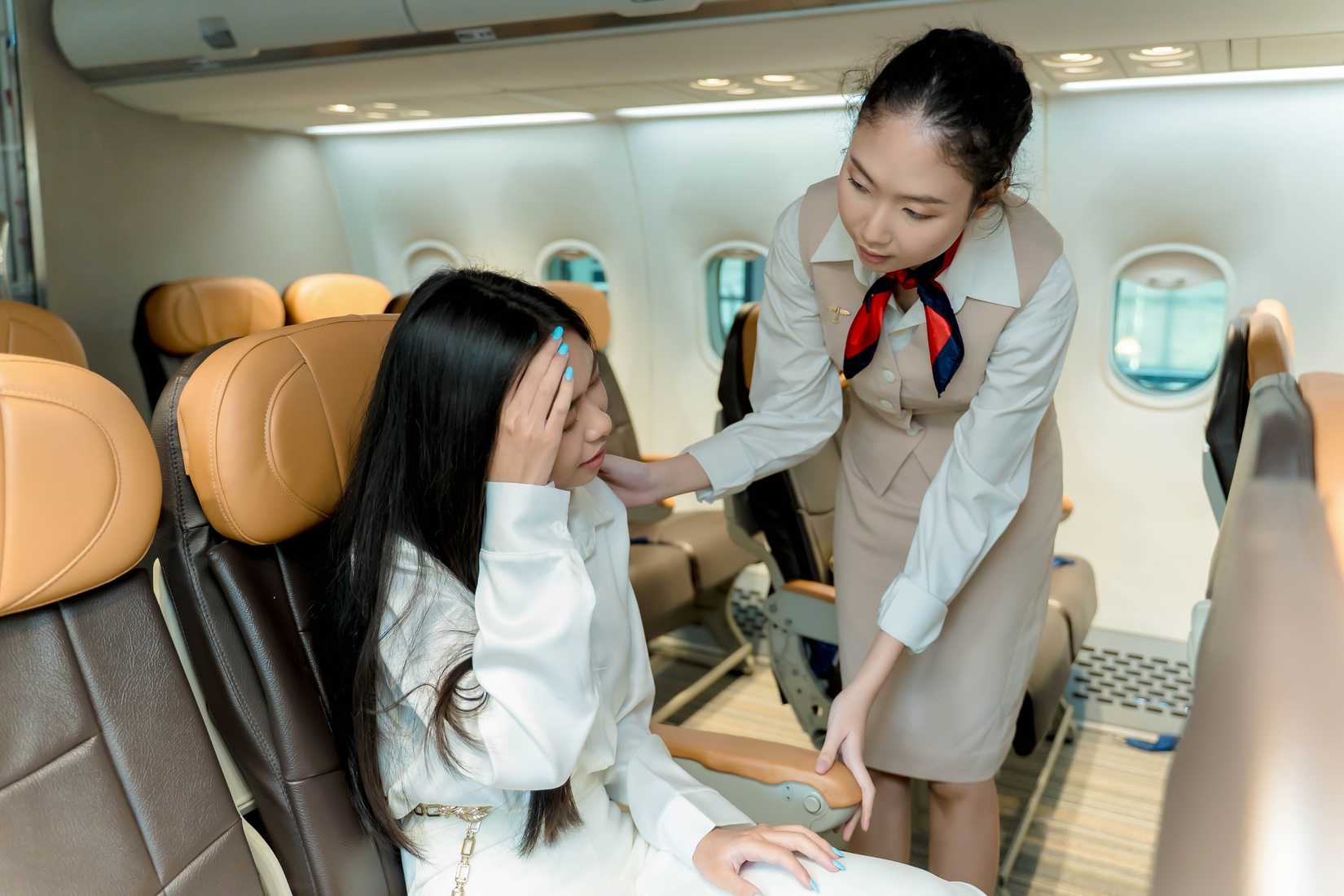flight attendant reassures woman on aircraft