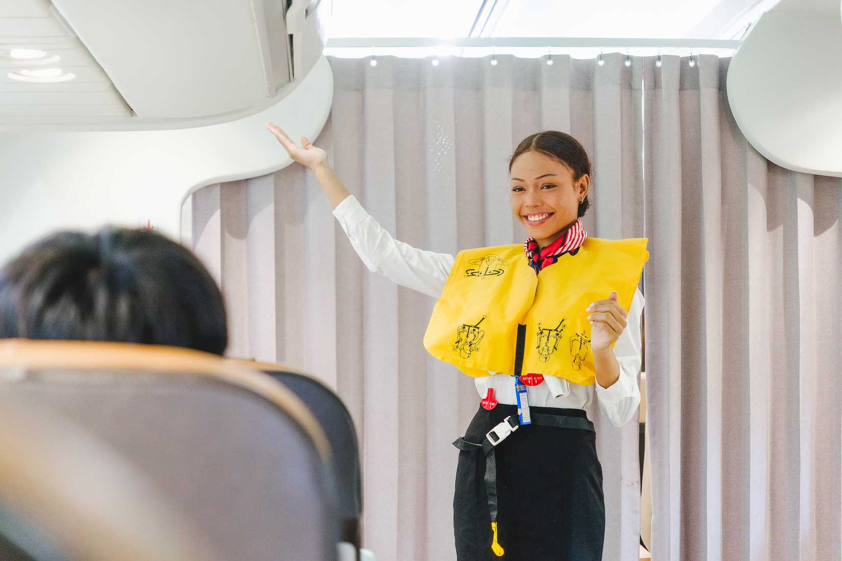 flight attendant in life vest in cabin