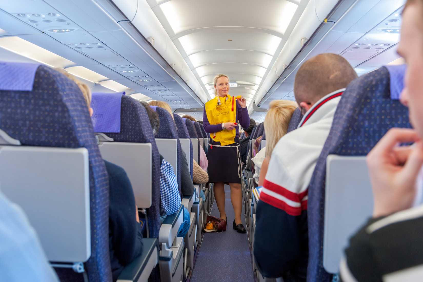 flight attendant performing safety demo in life jacket