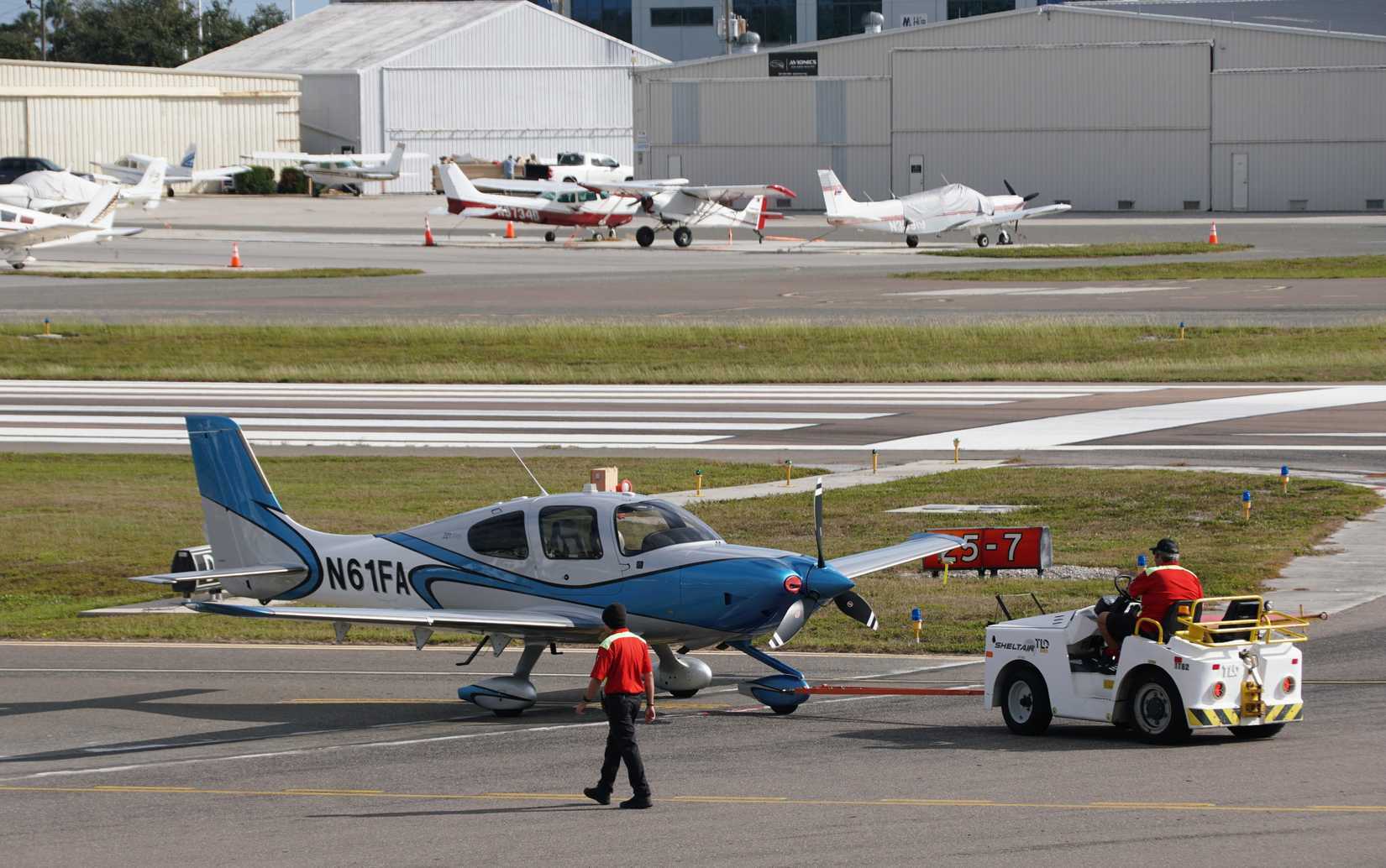 St Petersburg, Florida, U.S.A - Jan 3, 2026 - Single-engine aircraft towed by airport tug near hangars, showcasing ground operations and general aviation logistics at Albert Whitted Airport.