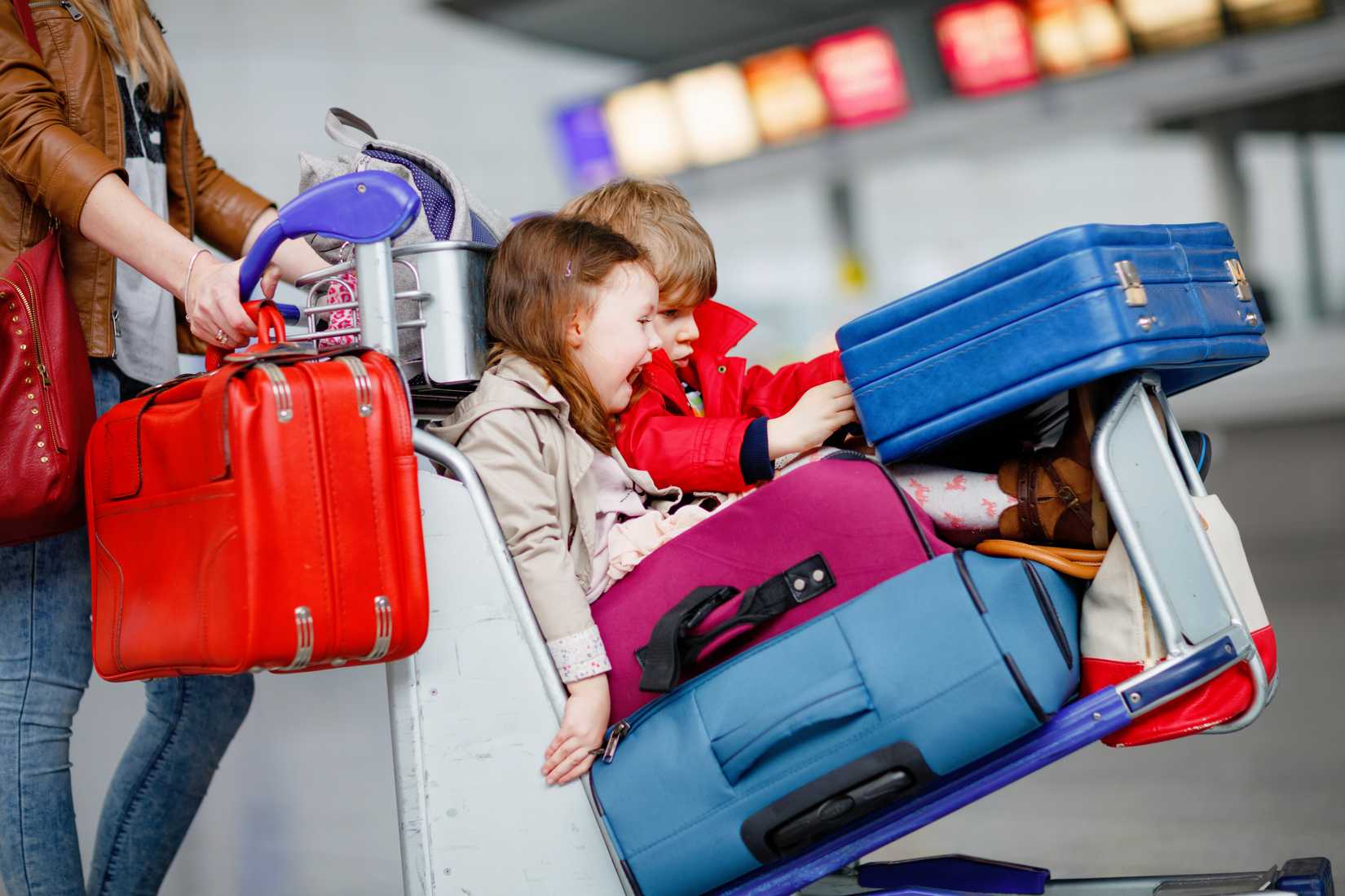 family at airport with luggage trolley