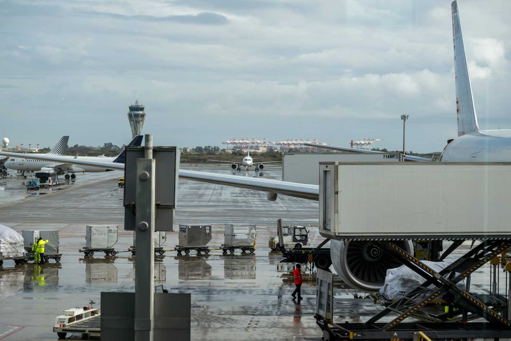 Cargo containers and baggage carts positioned across airport apron