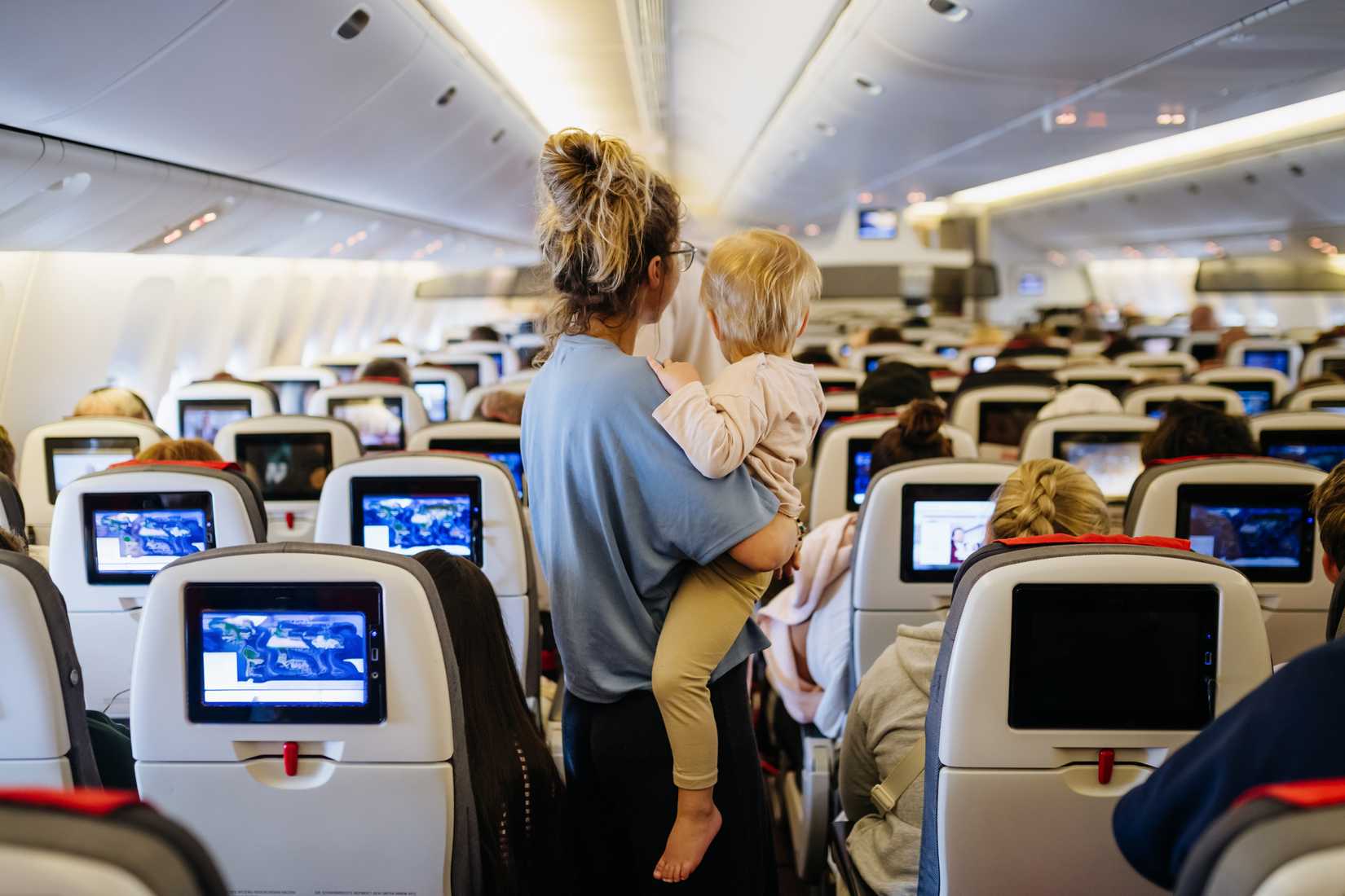 Mom and child standing in busy cabin