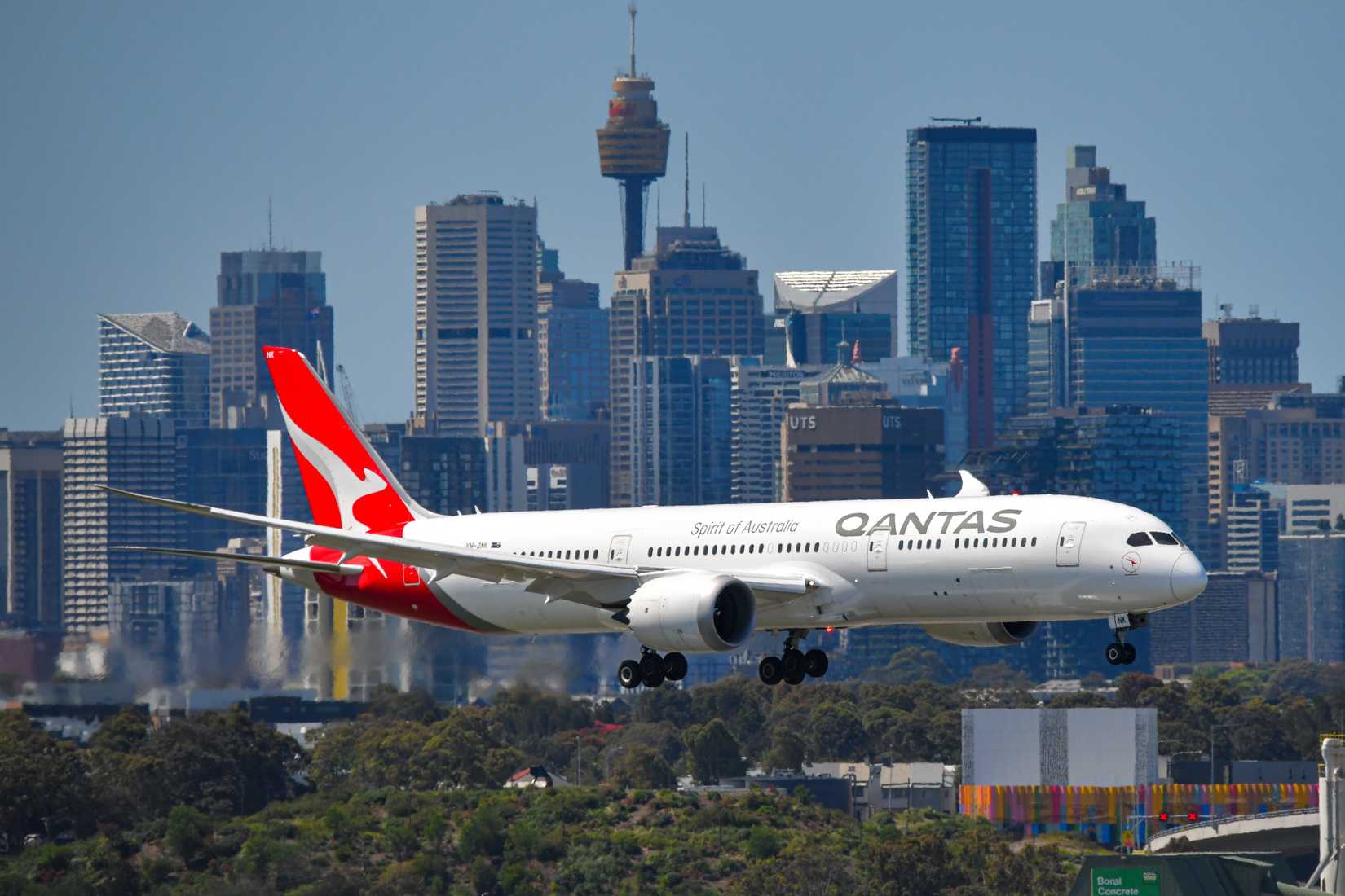 Sydney, NSW, Australia – October 25, 2022: Qantas Boeing 787-9 Dreamliner approaching Sydney Airport with city skyline in background
