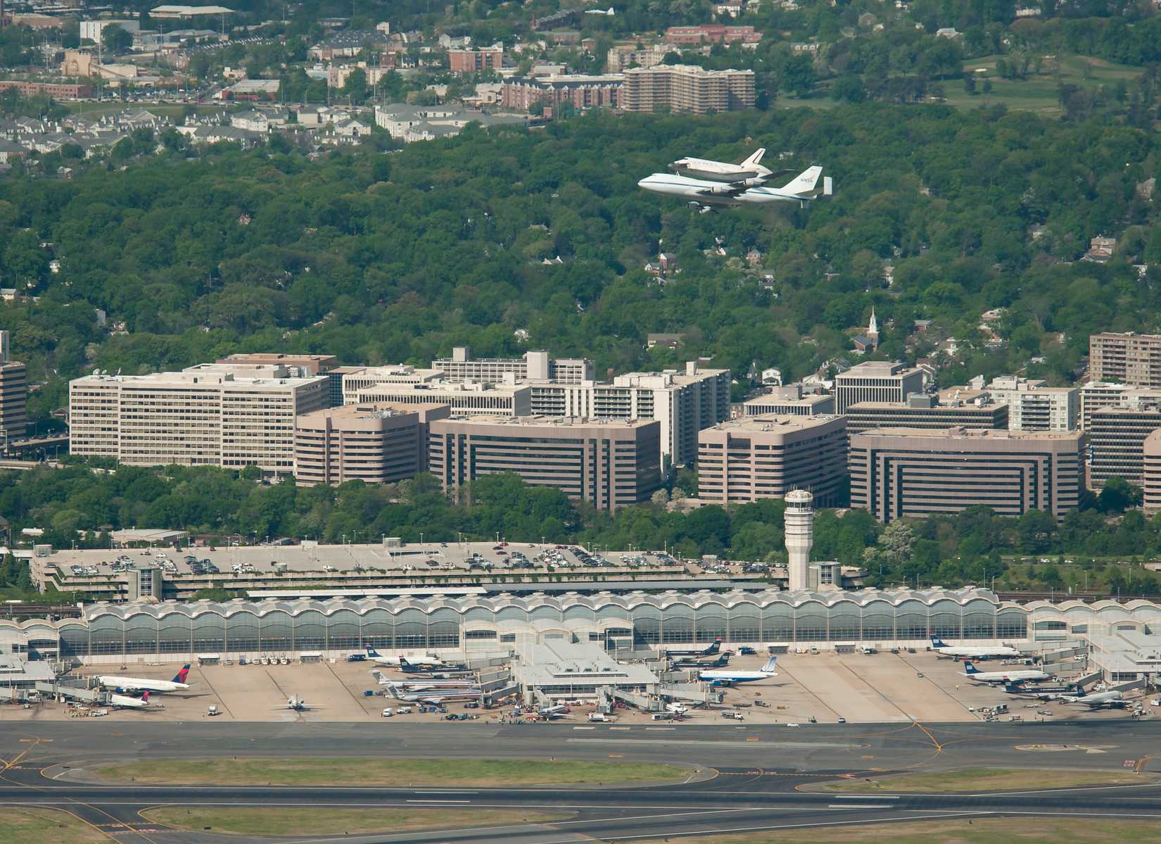 Space shuttle Discovery, mounted atop a NASA 747 Shuttle Carrier Aircraft (SCA) makes its way past Ronald Reagan Washington National Airport, Tuesday, April 17, 2012