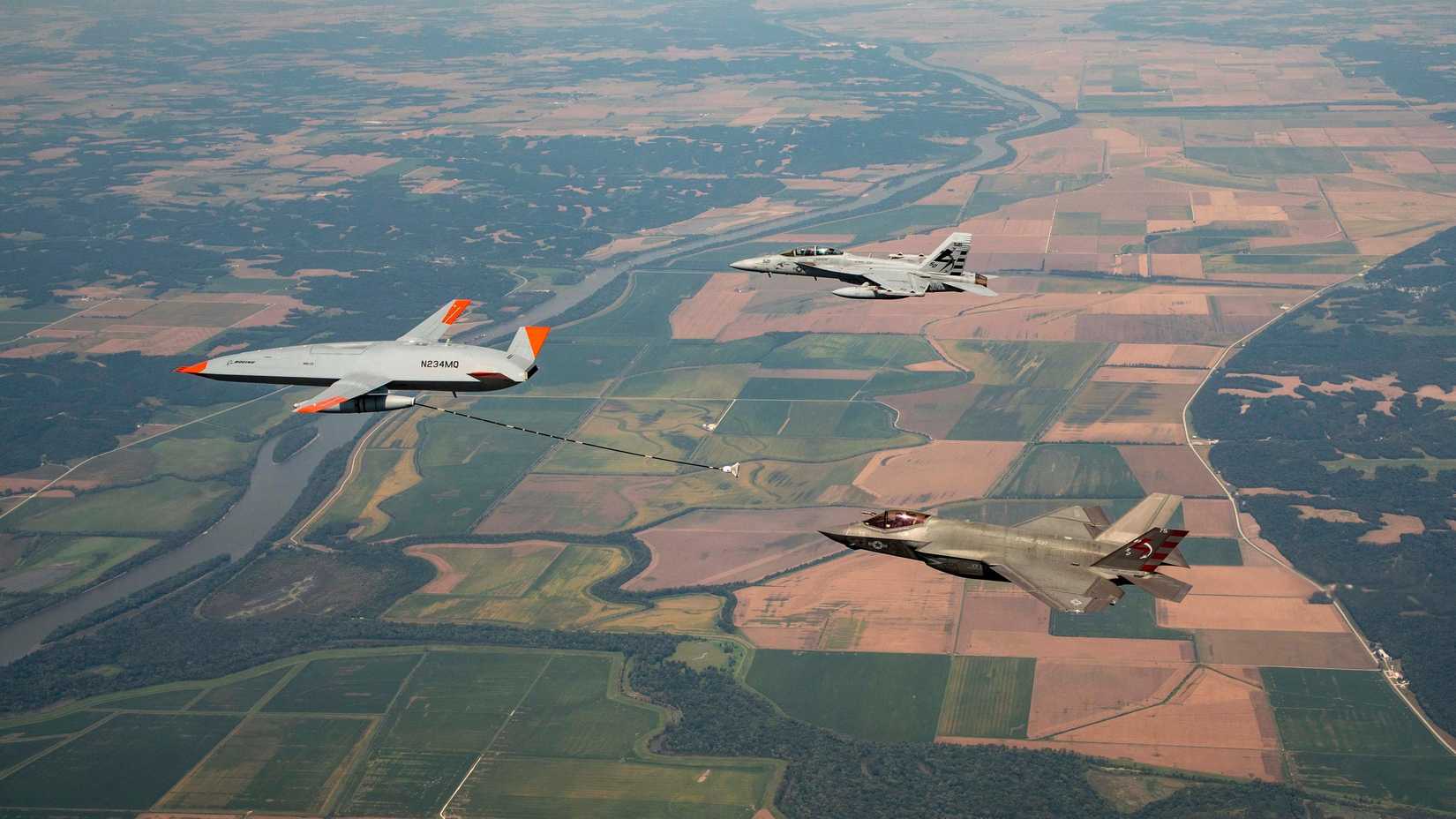 The F-35C Lightning II is refueled by the MQ-25 test asset as an FA-18 chase aircraft flies nearby during a test flight