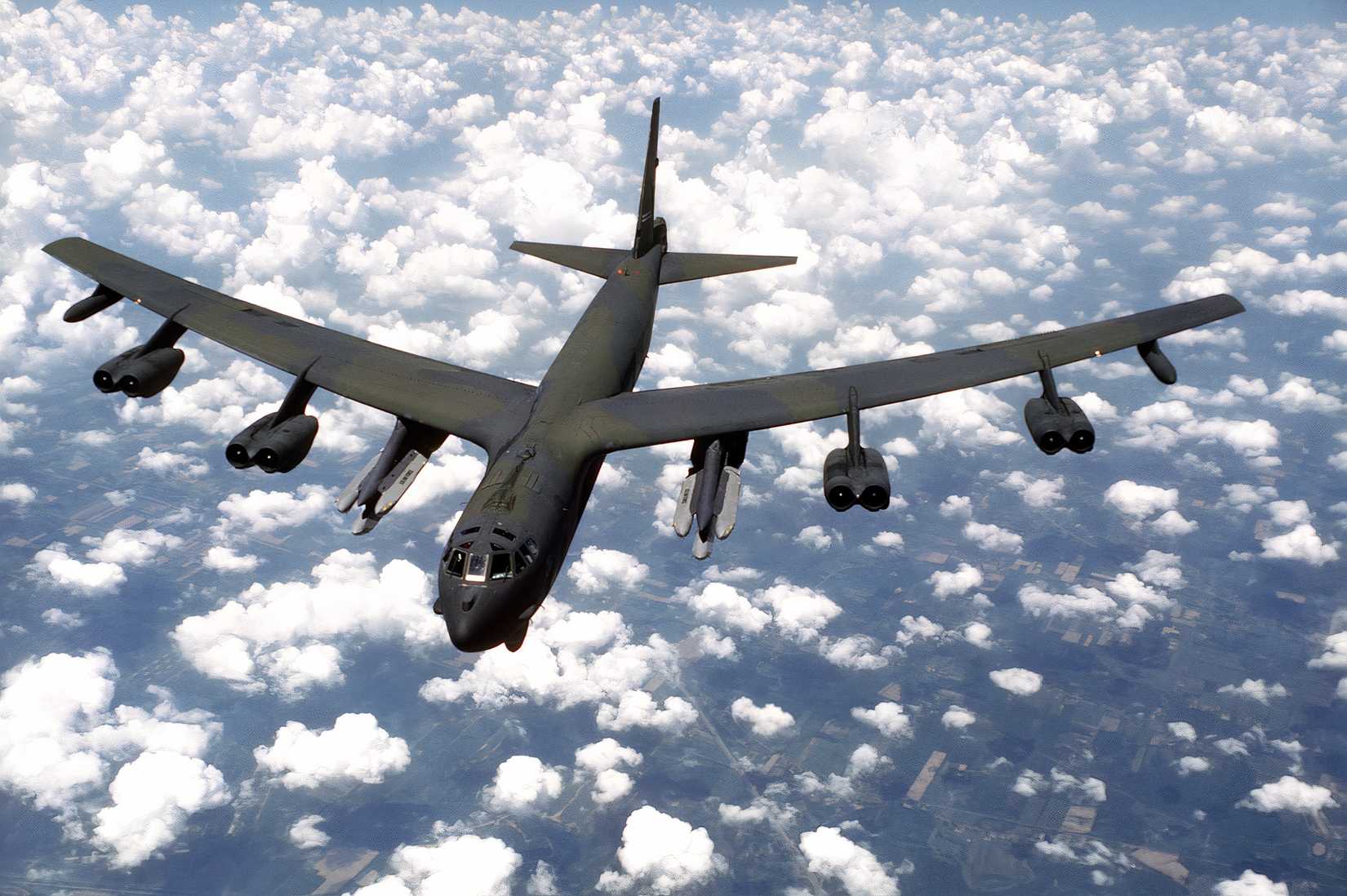 A photo showing a B-52 flying above the clouds armed with six cruise missiles.