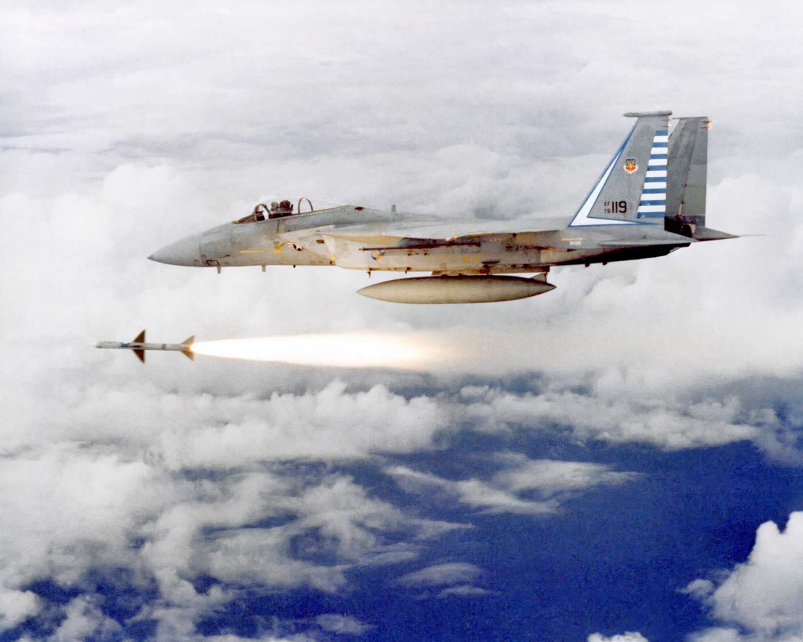 A photo of an F-15 firing a missile against a cloudy background. 