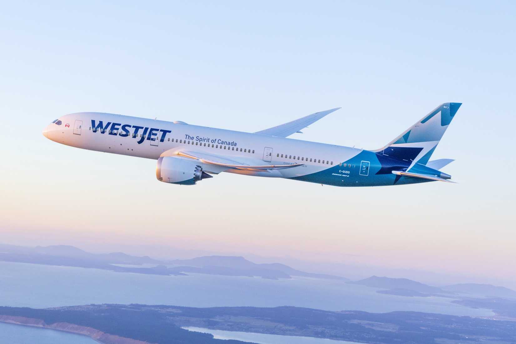 WestJet Boeing 787-9 flying over the coast