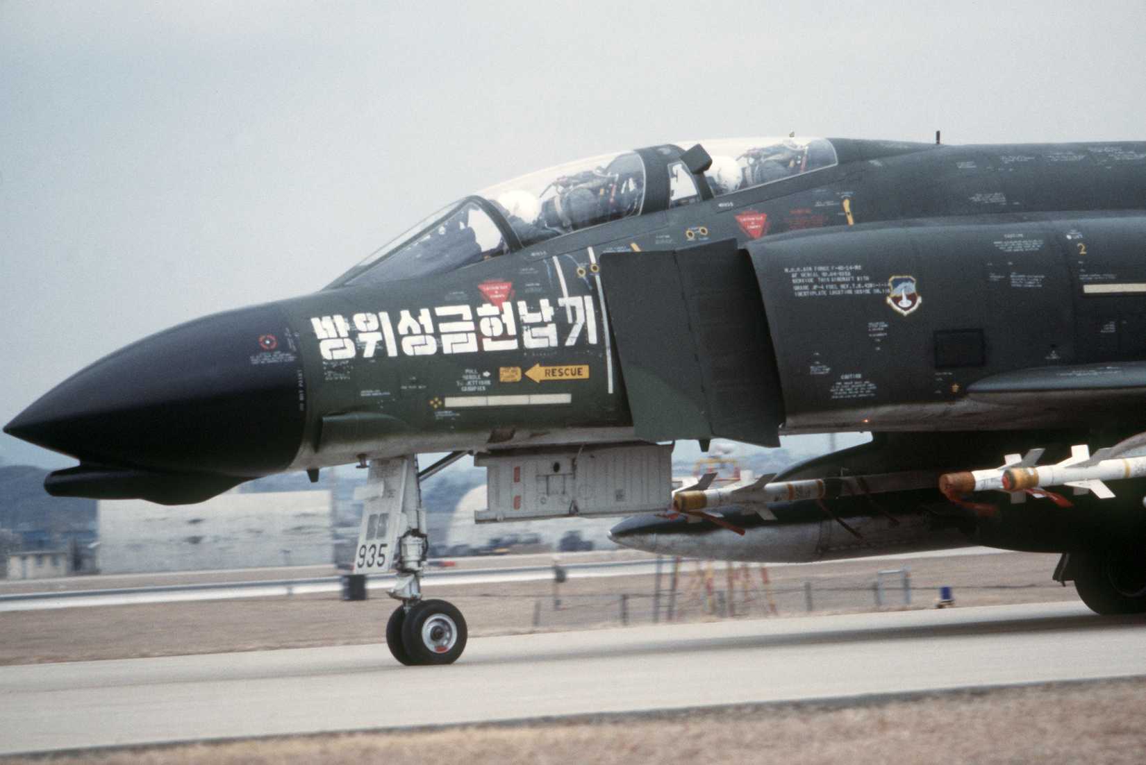 A Korean air force F-4 Phantom II aircraft armed with AIM-9 Sidewinder missiles taxis on the flight line