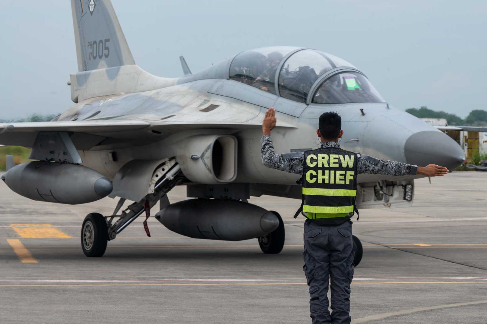 A Philippine Air Force member marshals in an FA-50 Fighting Falcon at General Santos International Airport, Philippines, July 11, 2023.