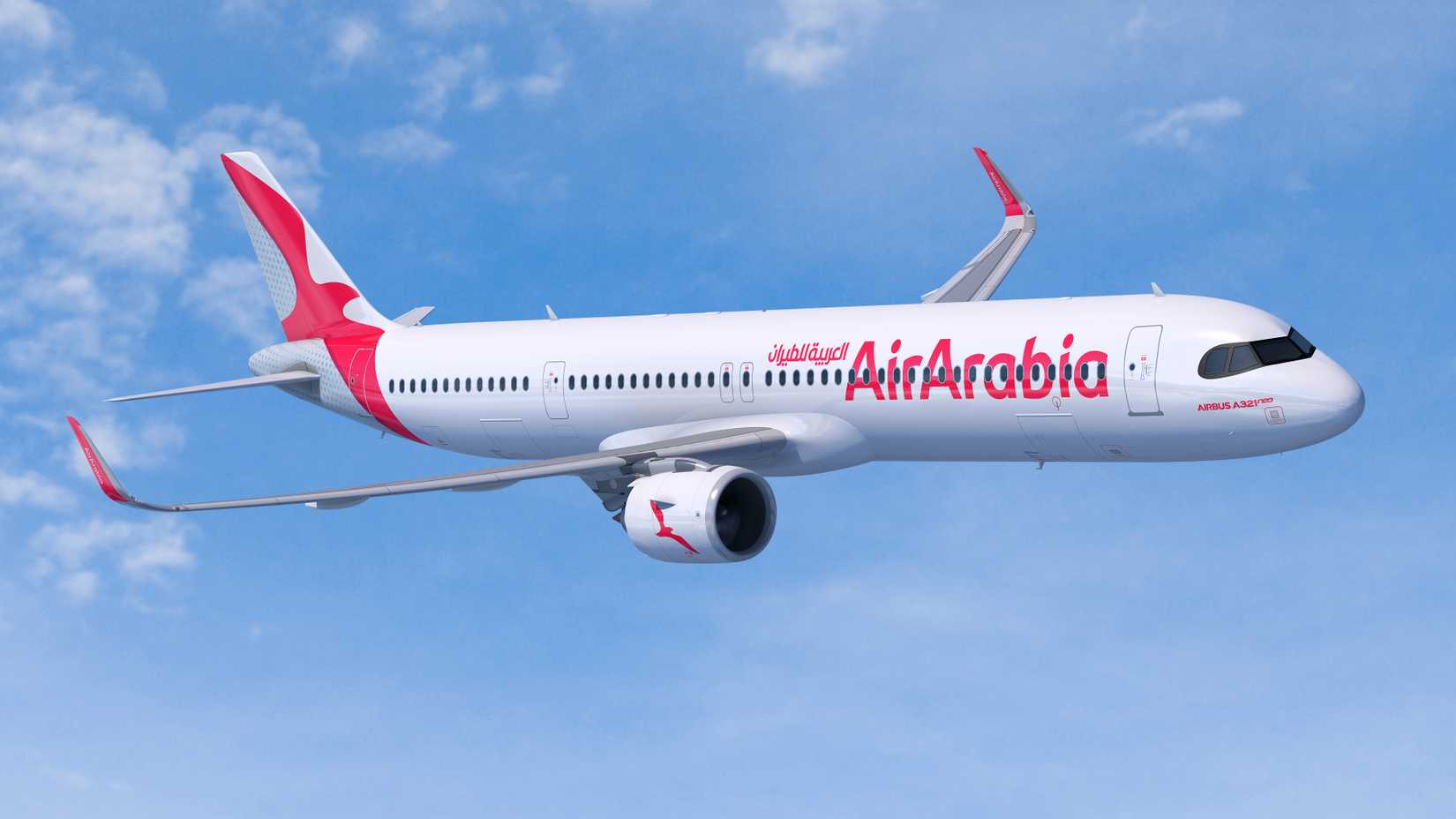 Air Arabia Airbus A321XLR flying in front of a blue sky with few clouds.