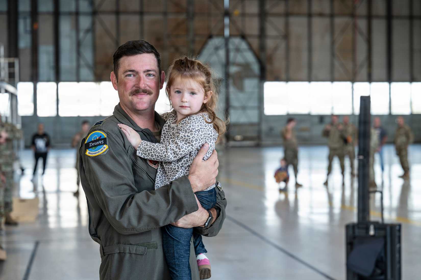 Air Force Capt. Adam Gonce, 166th Air Refueling Squadron pilot, greets his family upon return from a deployment to the Indo-Pacific Command
