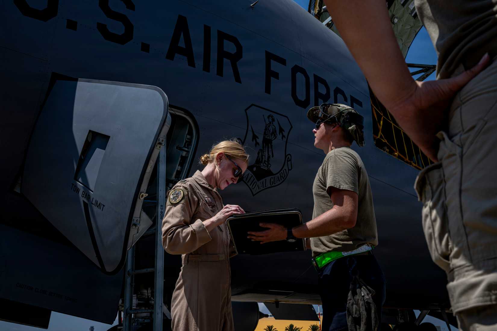 Airmen read over preflight documents for a U.S. Air Force KC-135 Stratotanker aircraft at a base in the U.S. Central Command area of responsibility