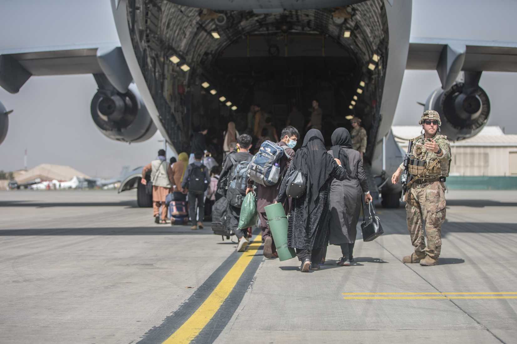 amilies begin to board a U.S. Air Force Boeing C-17 Globemaster III during an evacuation at Hamid Karzai International Airport, Kabul, Afghanistan