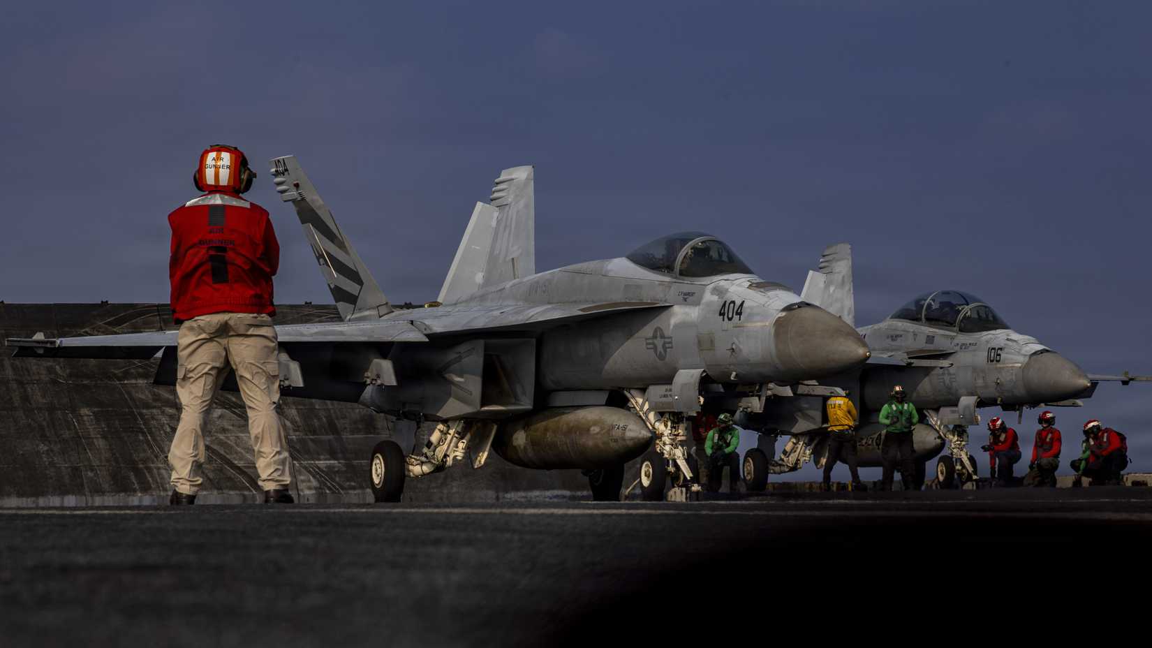 An FA-18E Super Hornet, left, and an FA-18F Super Hornet,prepare to launch from the flight deck of Nimitz-class aircraft carrier USS Abraham Lincoln (CVN 72)