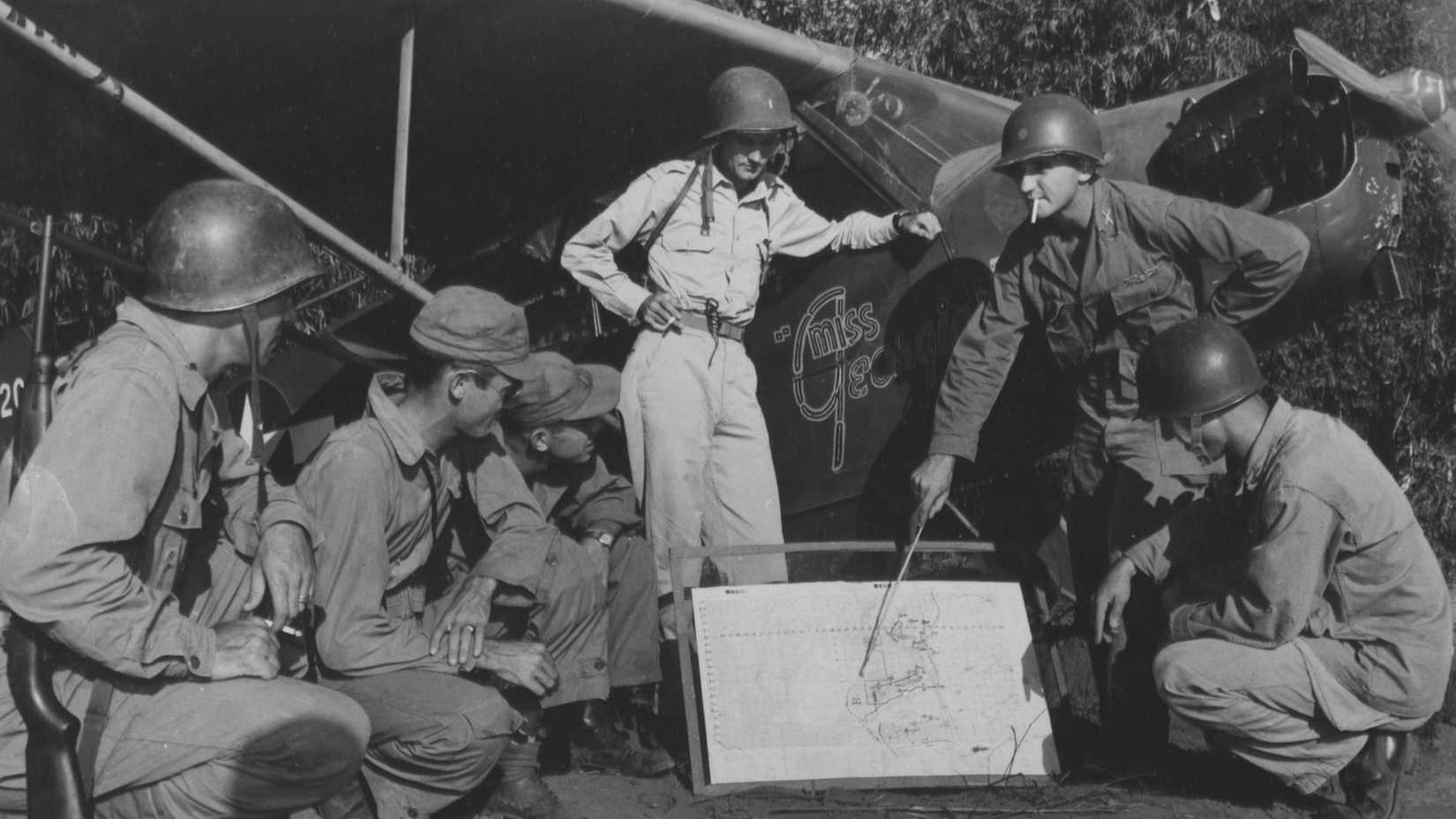 At the first crack of dawn, Major James A. Williams of Ontario, California, briefs pilots of Piper L-4's who serve as observers for the 40th Division during the fierce battle to recapture Clark Field, Luzon, Philippine Islands.