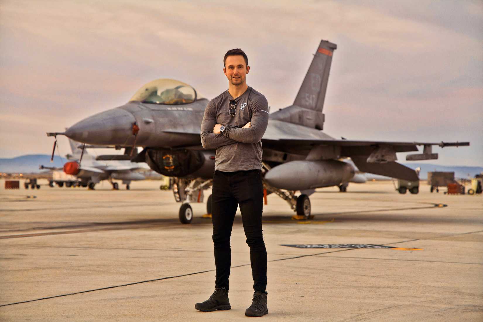 A photo of Louis Skupien standing in front of an F-16.
