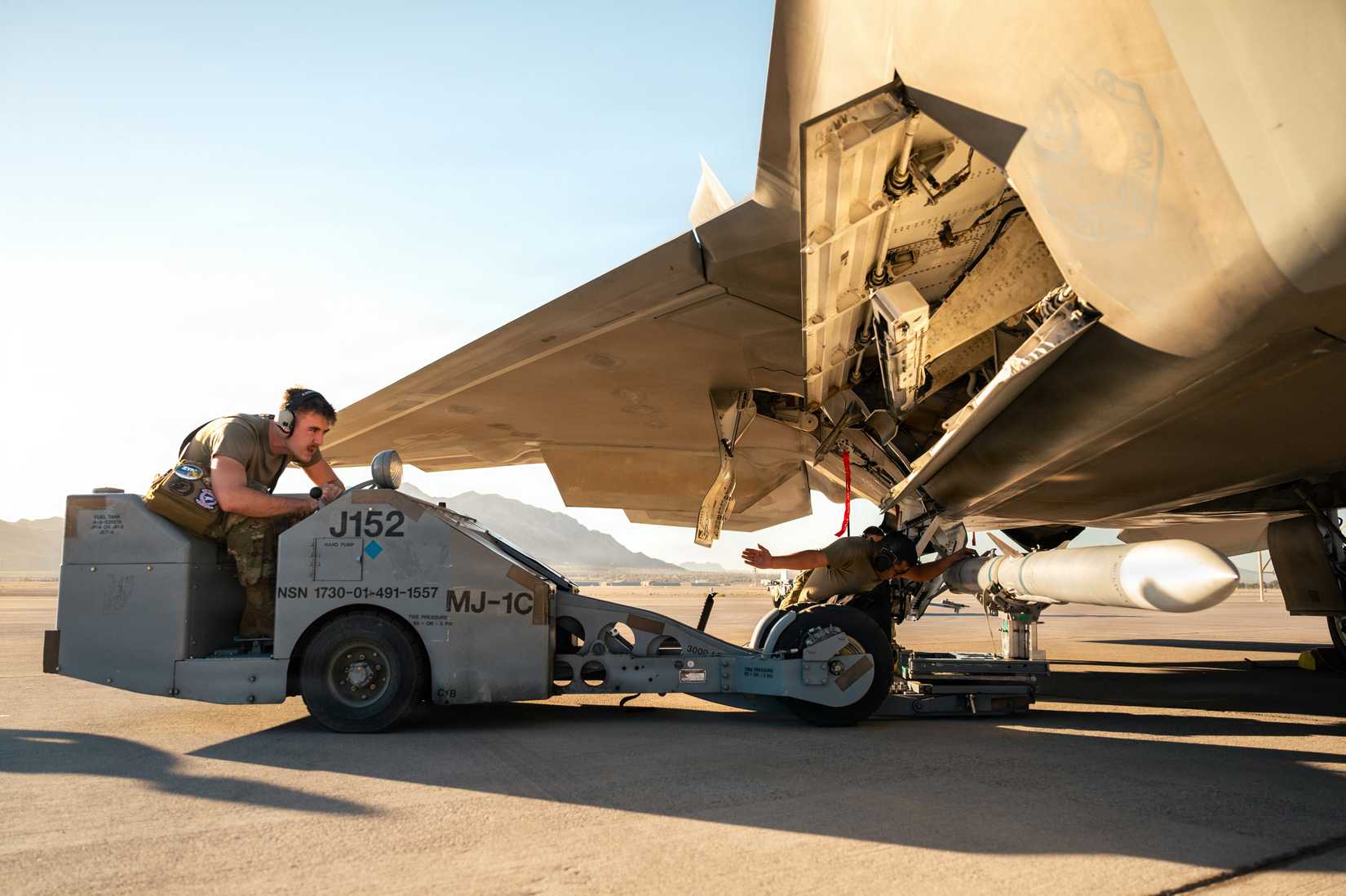 Crew load an inert munition on an F-22A Raptor aircraft at Nellis Air Force Base, Nevada, Oct. 2, 2026.