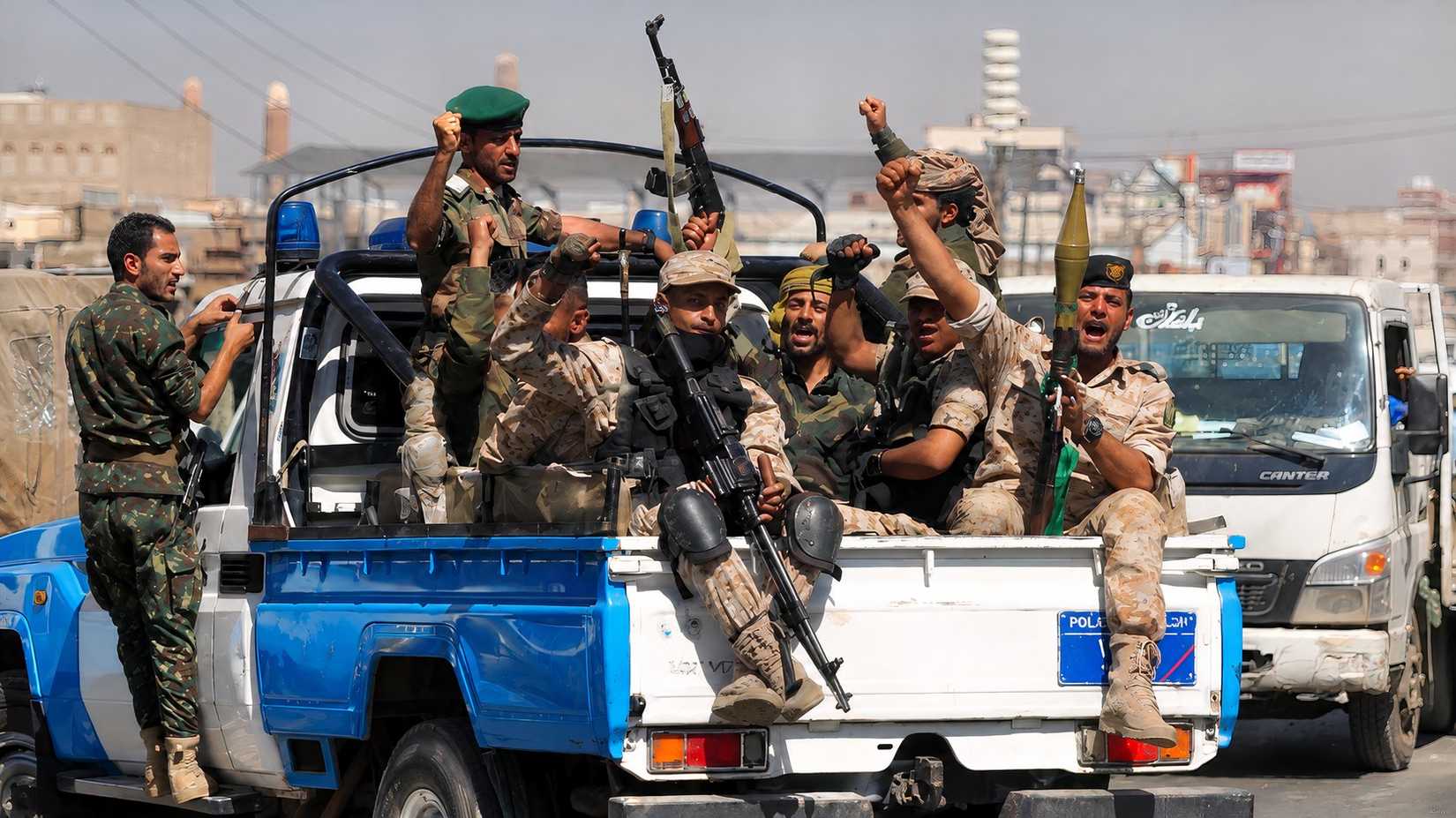  ​​​​​​​A group of armed Houthi militants sit in the back of a police pick-up truck.