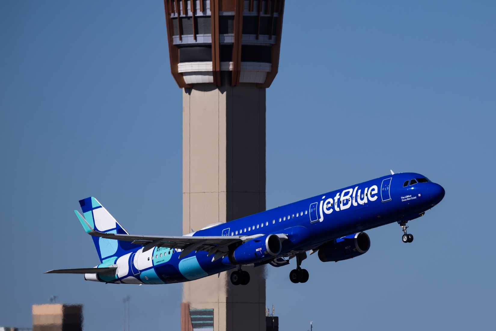 JetBlue Airways takeoff with control tower behind