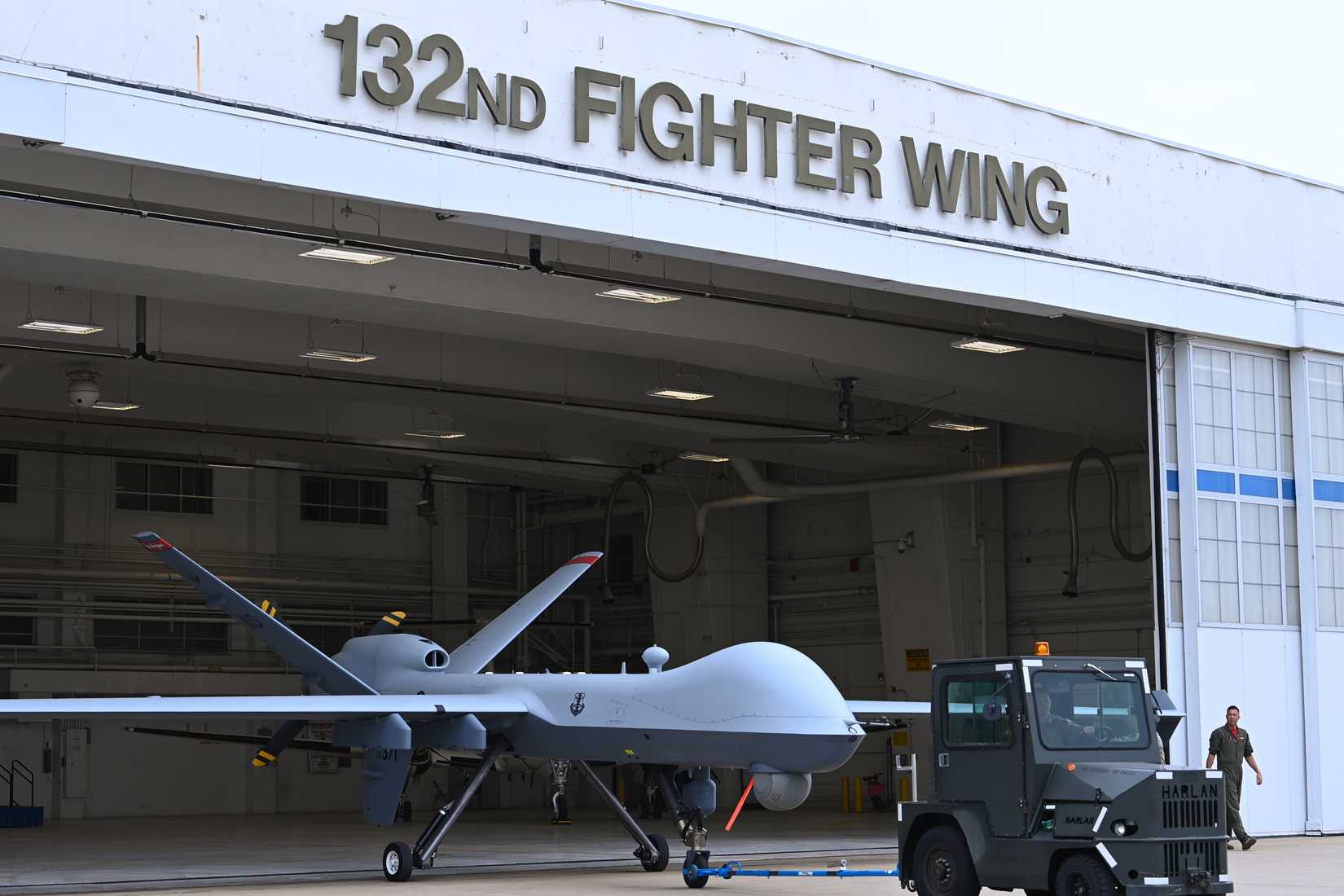 Members of the 132d Wing and 119th Wing wheel out the MQ-9 Reaper from the hangar that previously housed F-16 Fighting Falcons