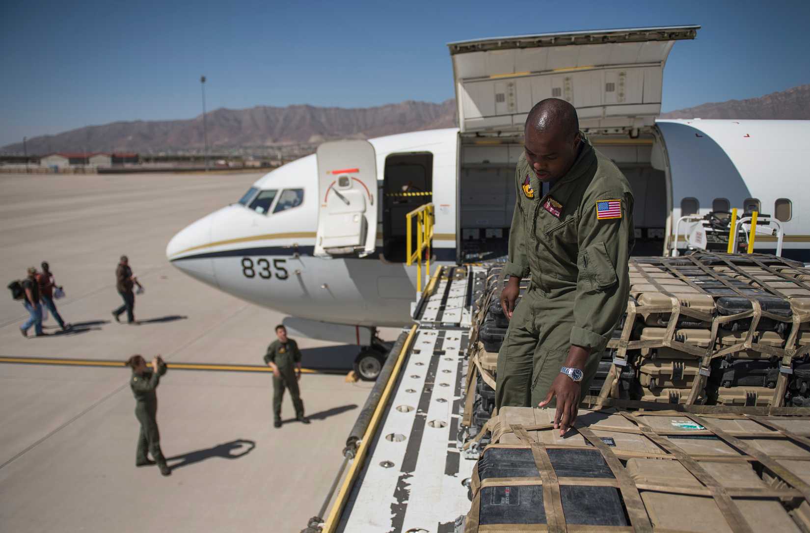 Naval Aircrewman Fred Johnson, a loadmaster assigned to Fleet Logistics Support Squadron (VRC) 57, inspects cargo pallets before they are loaded onto a C-40A Clipper at Biggs Army Airfield.