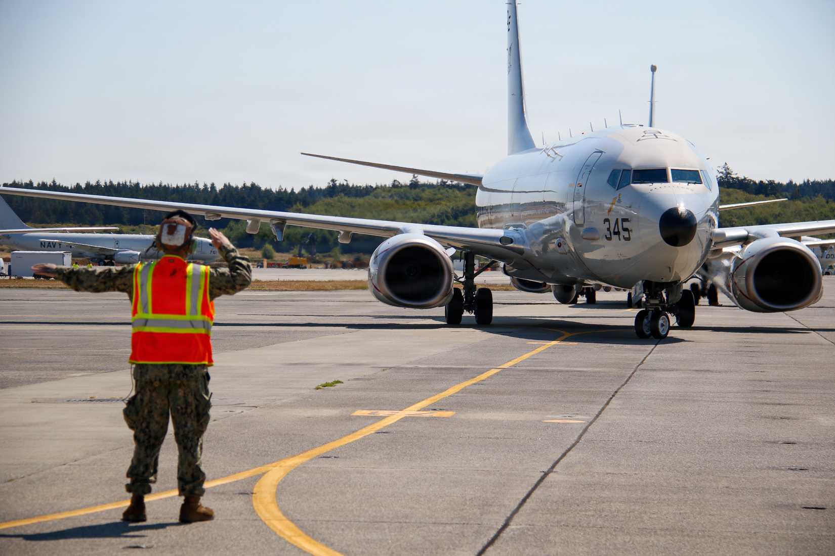 Patrol Squadron (VP) 40, marshals a P-8A Poseidon aircraft on the flightline at Naval Air Station Whidbey Island