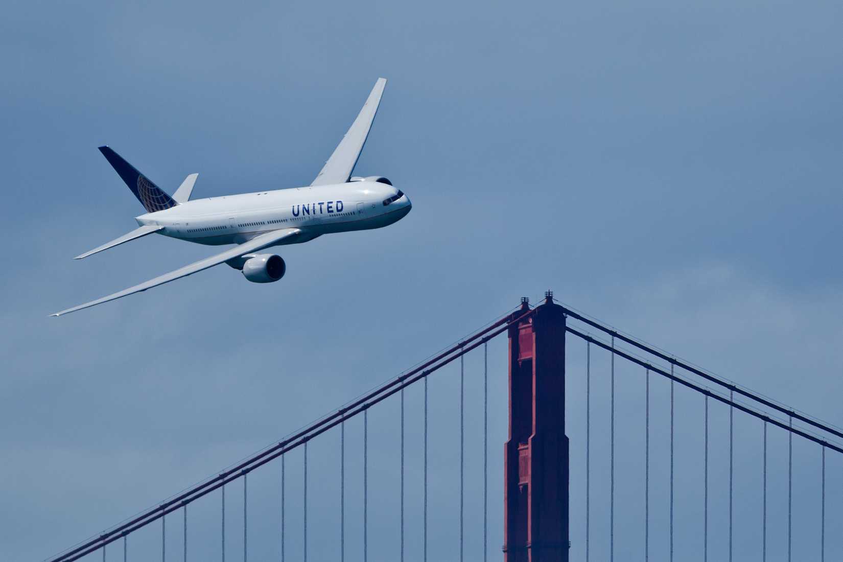 A United Airlines Boeing 777 overflying San Francisco's Golden Gate Bridge