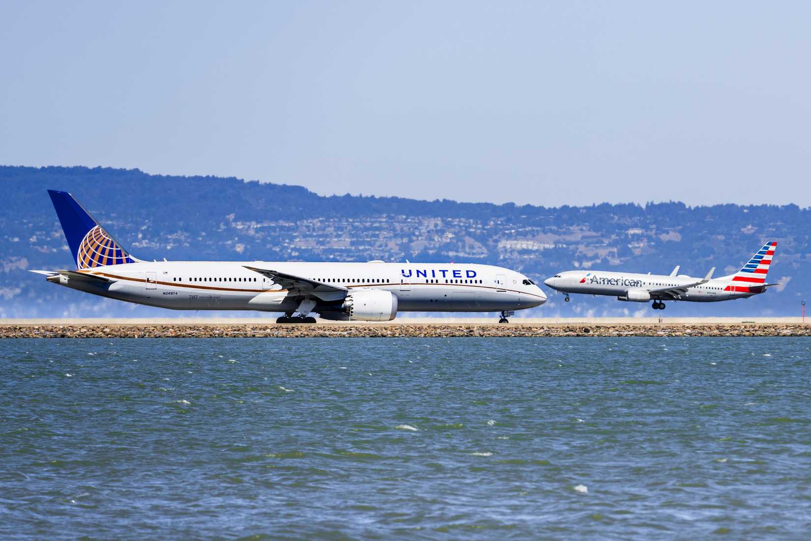 September 1, 2019 Burlingame / CA / USA - United Airlines aircraft preparing to take off and American Airlines aircraft landing at San Francisco International Airport (SFO)