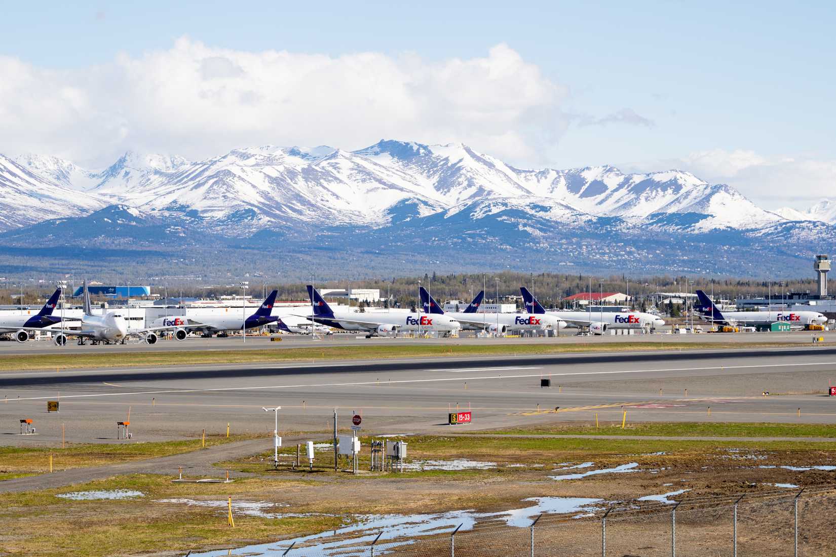 Anchorage, Alaska - May 12 2024: FedEx ramp in Anchorage full of planes waiting to deliver cargo around the world. 