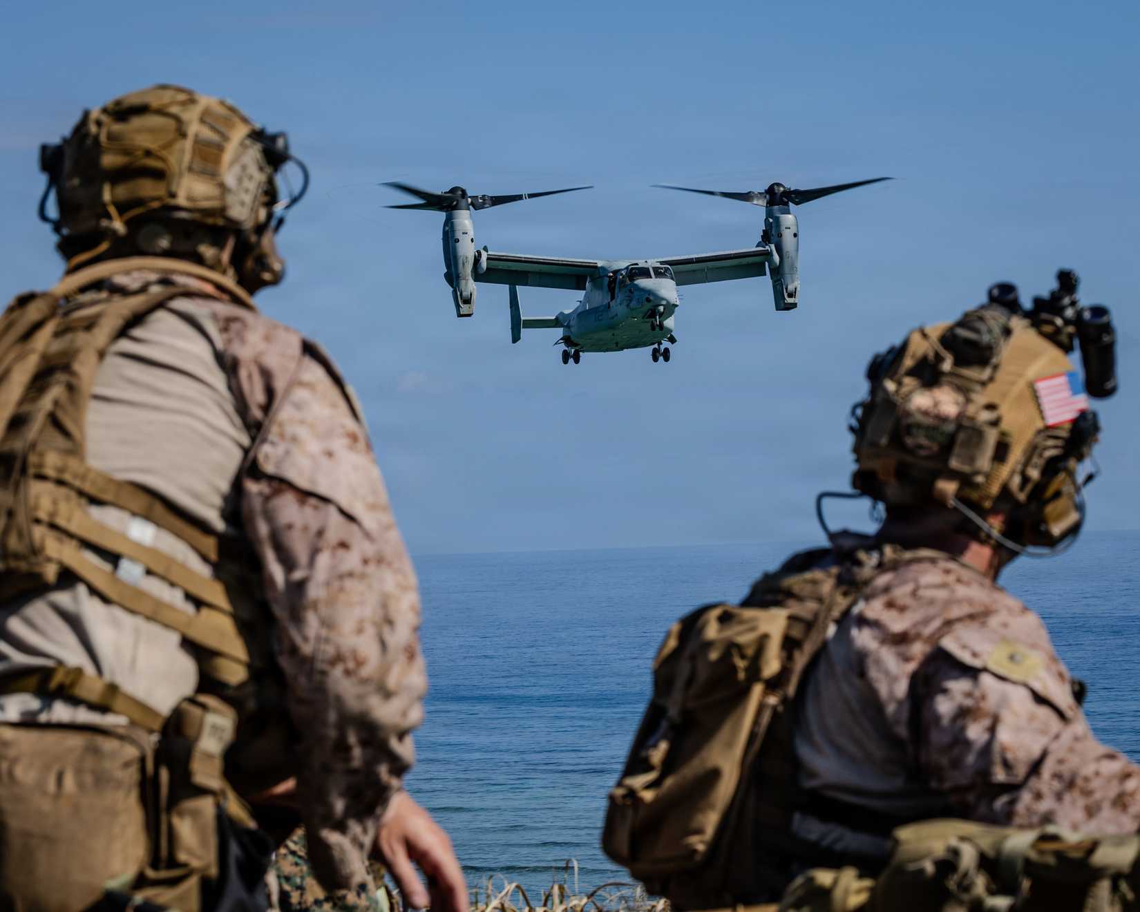 Osprey Flying Past Two Servicemen