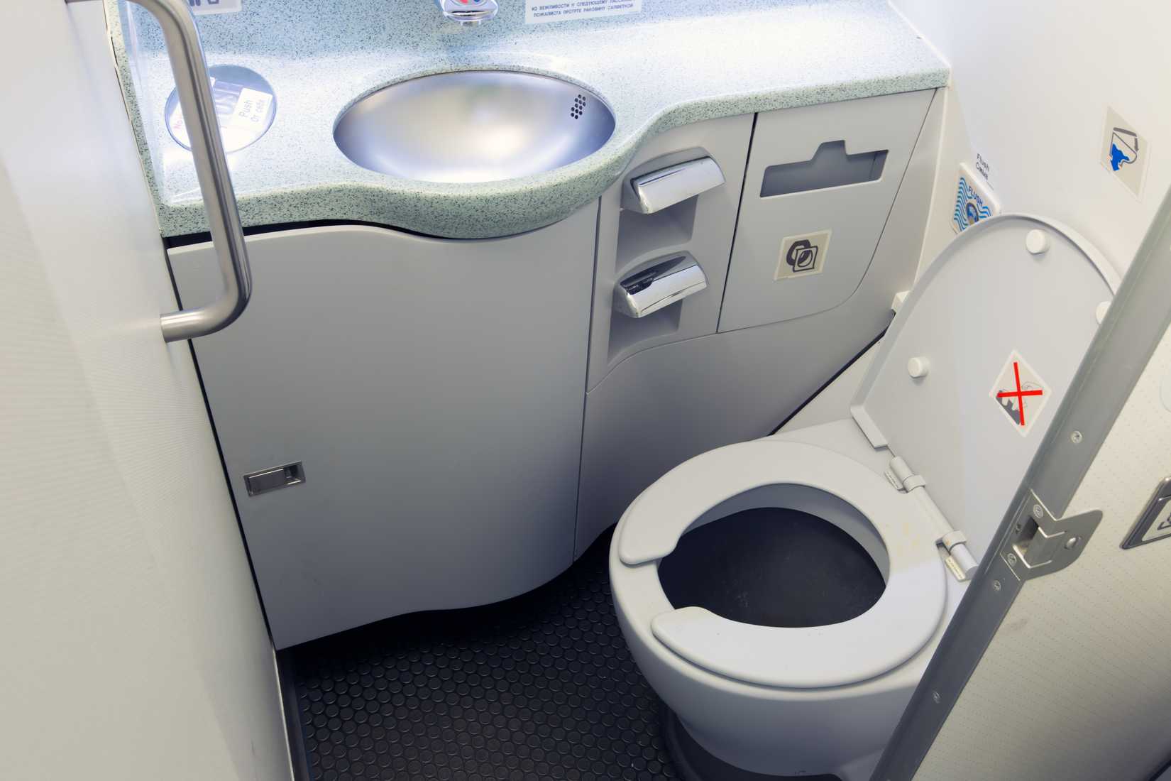 Airplane lavatory. Toilet seat and wash basin close-up