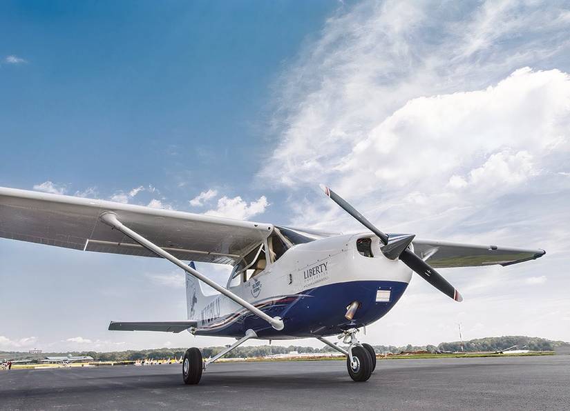 A close-up photo of a Cessna 172 Skyhawk parked with while clouds above.