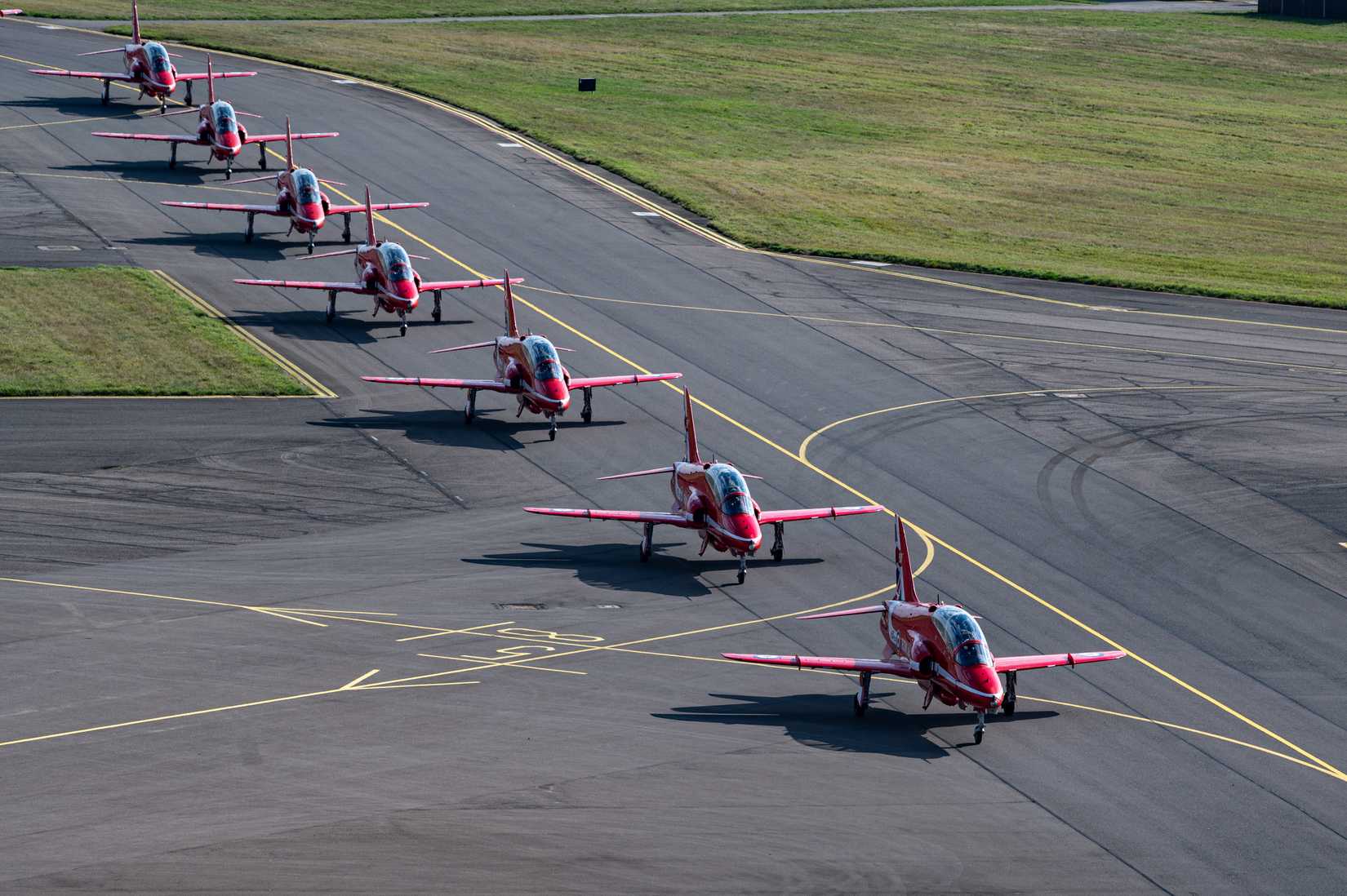 The Royal Air Force Aerobatic Team, the Red Arrows, taxi along the flight line after an aerial display at RAF Mildenhall