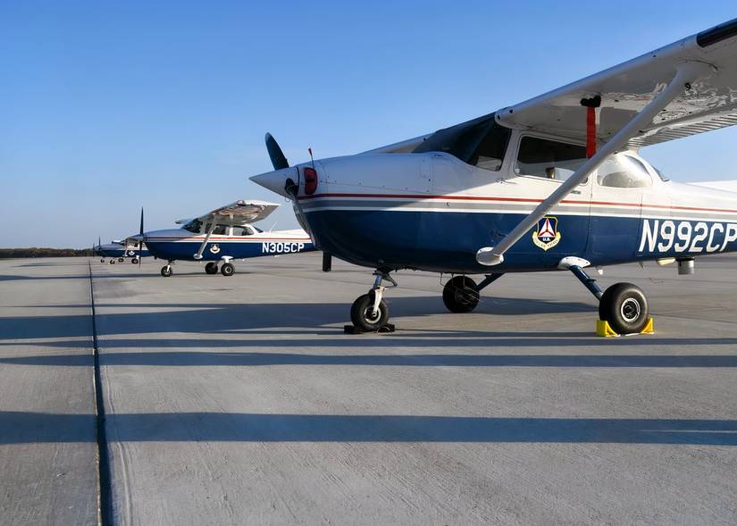 Several Cessna 172s belonging to the US Air National Guard are parked on an apron. 