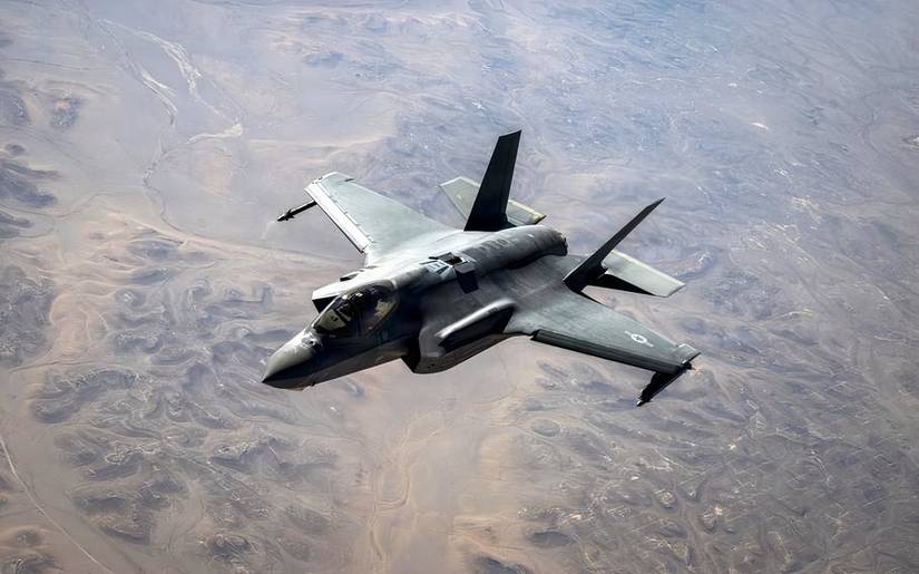 A photo of an F-35 flying over the desert.