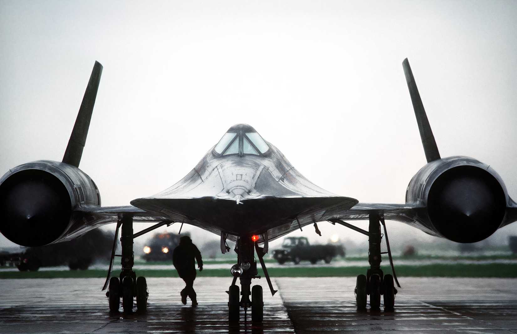 A photo of an SR-71 parked against a grey rainy day. 